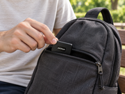 Compact petZeye GPS 913 tracker being placed inside a backpack pocket