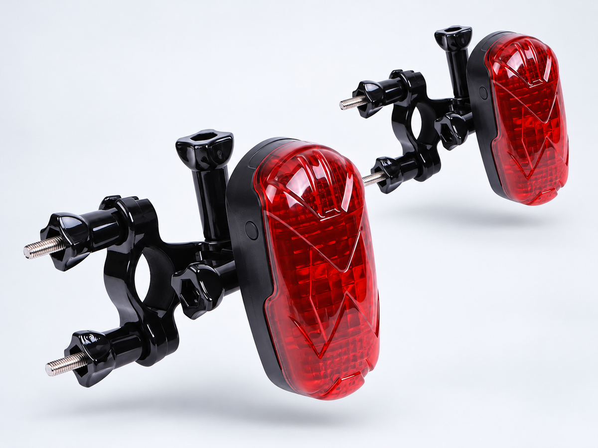 Two petZeye GPS 906 bicycle trackers showing their red rear lights and mounting brackets
